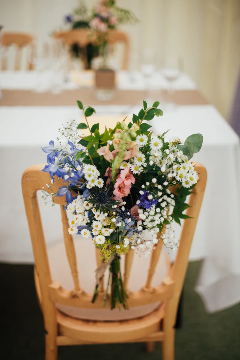 Wildflower posy tied to the back of a wooden reception chair